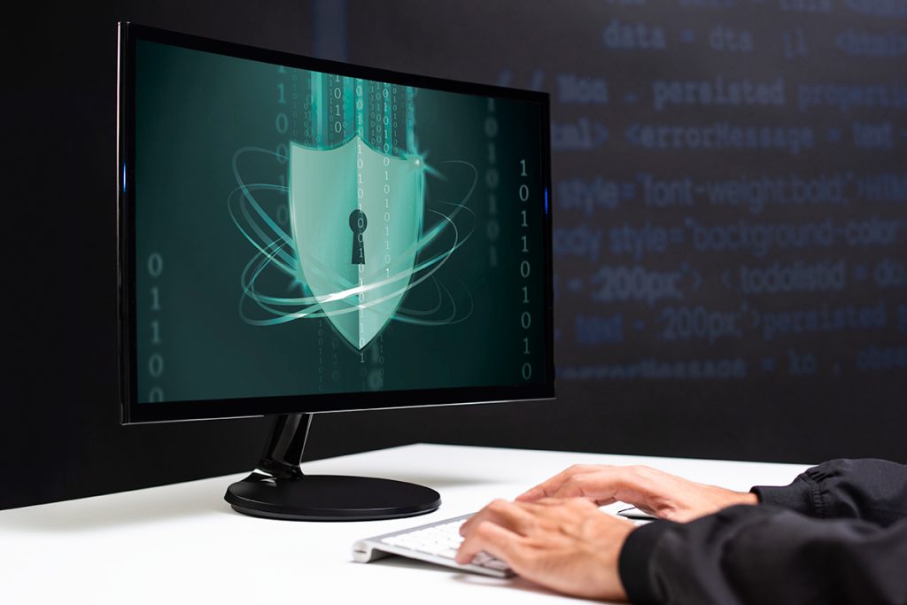 monitor ligado com pessoa operando um programa de cibersegurança